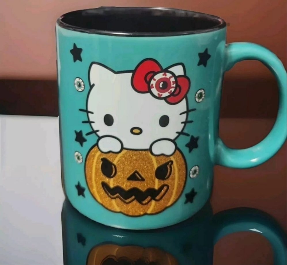 Hello Kitty pumpkin mug featuring Hello Kitty with a glittery pumpkin design and playful stars