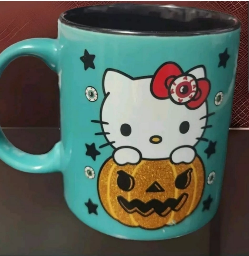 Hello Kitty pumpkin mug featuring a cute design with a jack-o-lantern and whimsical stars