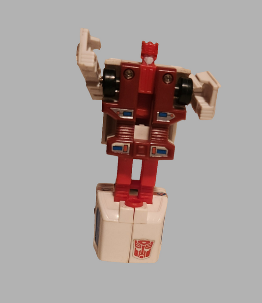 Transformers Protectobots Groove toy in red and white, featuring articulated arms and classic design