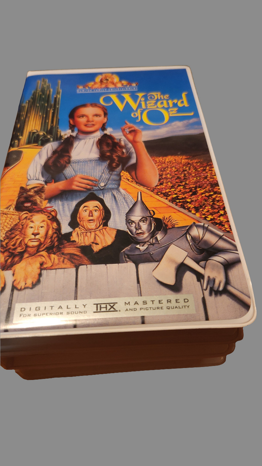 The Wizard of Oz collectibles featuring a classic VHS cover with iconic characters and vibrant graphics